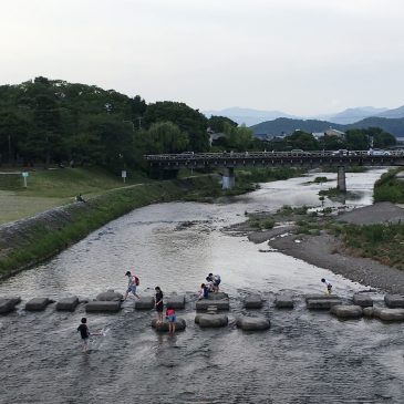 Photographer crossing the Kamoriver at Demachiyanagi, Kyoto.